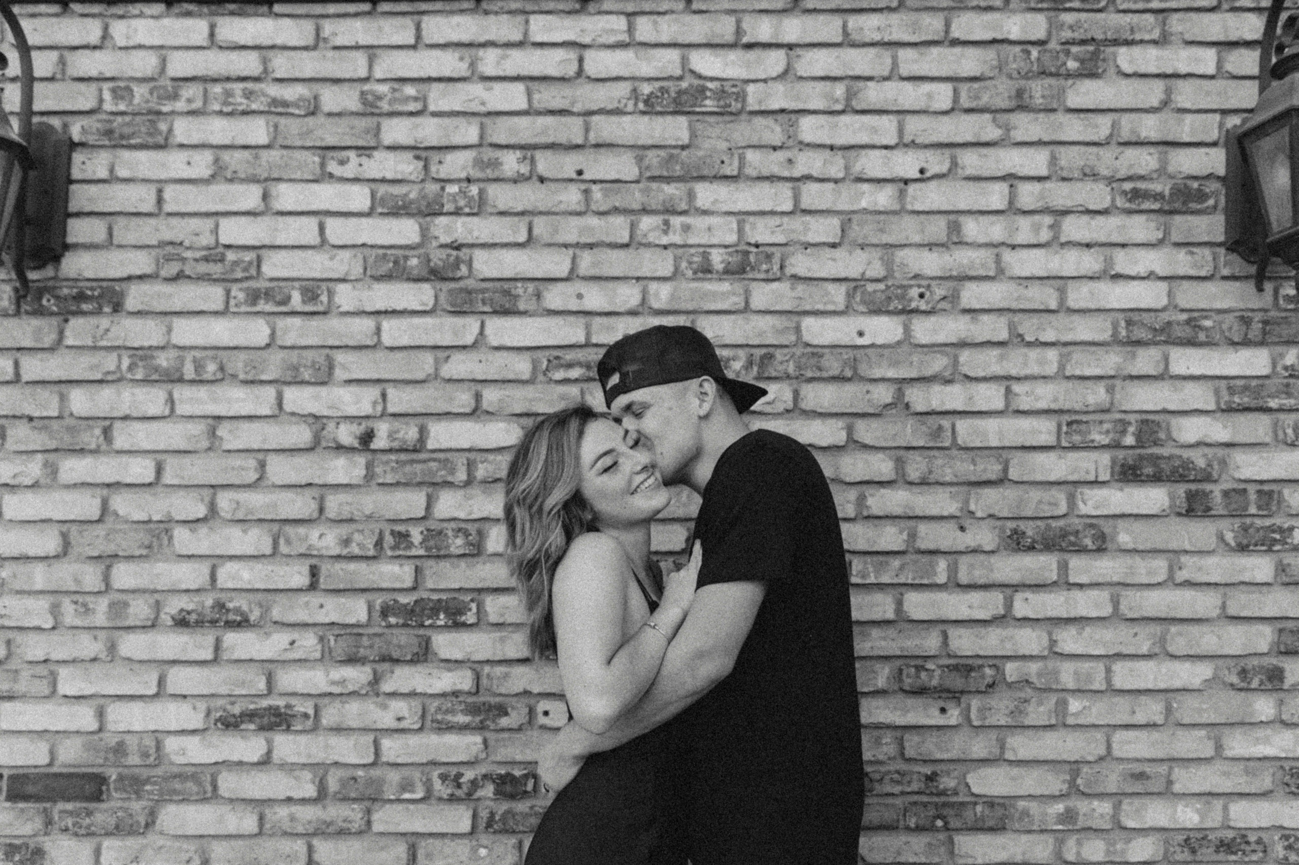 downtown couples session in front of a brickwall