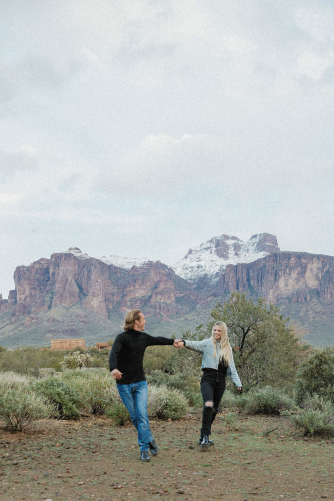 Couple walking in front of the Superstition Mountains 