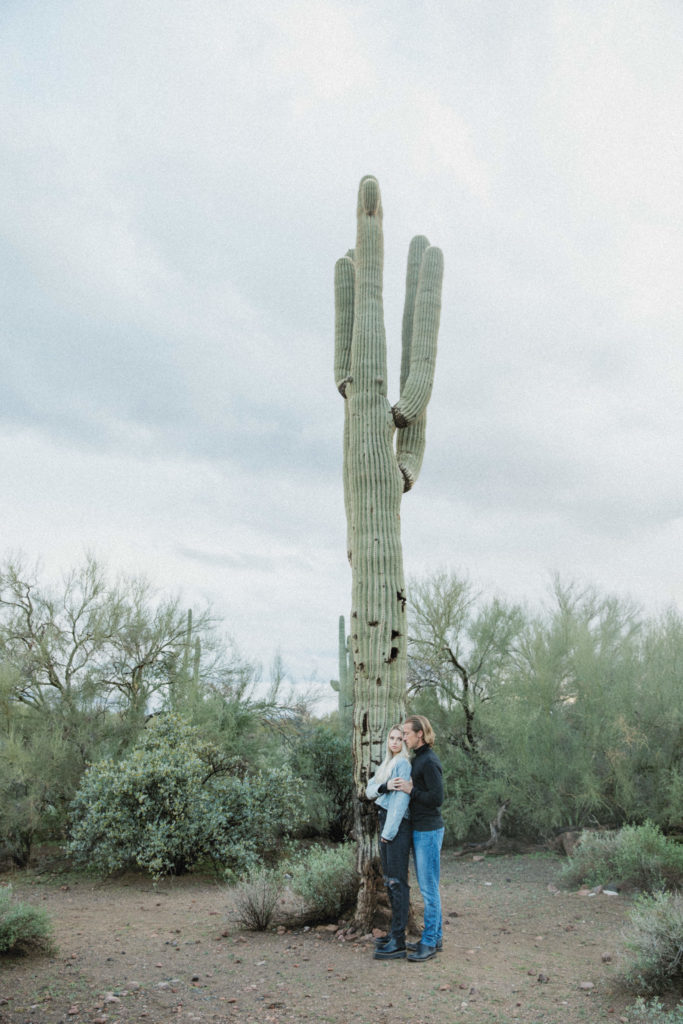 Couple posing in front of a cactus 