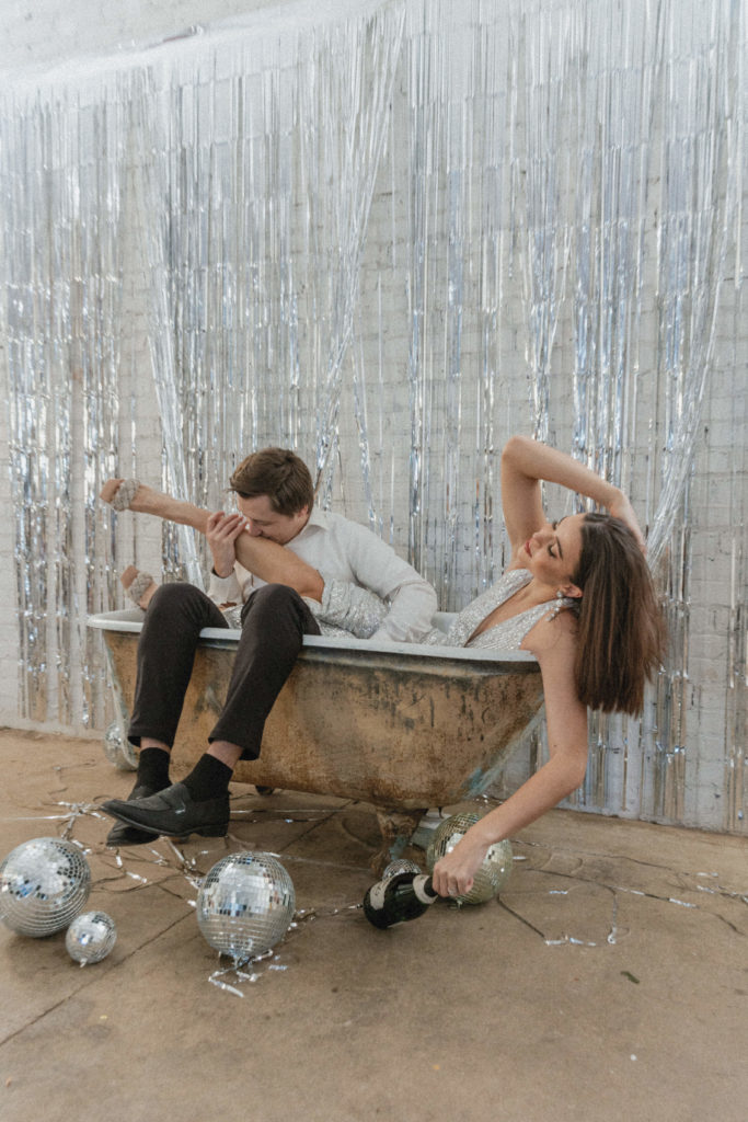 couple sitting in a bathtub and drinking champagne 