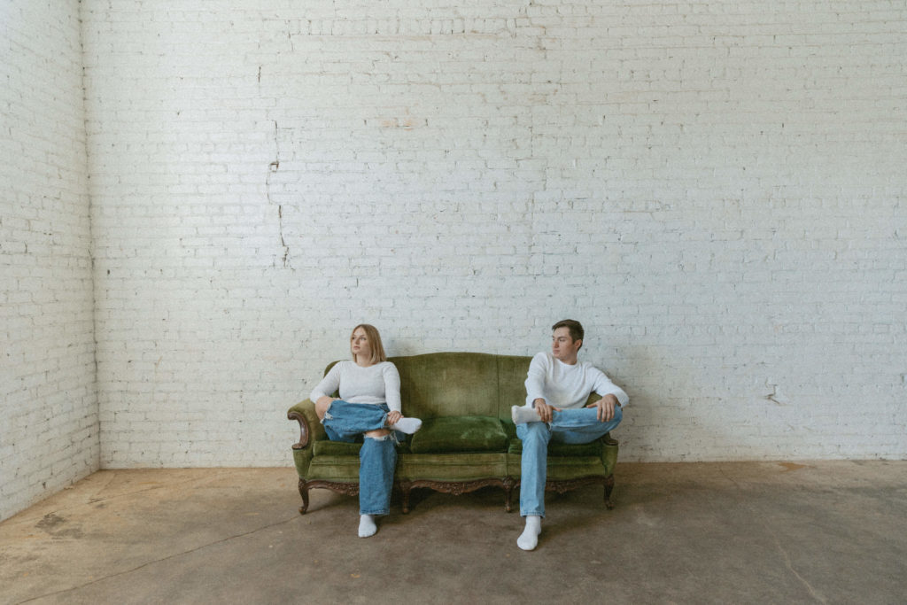 couple sitting on either on of a couch 