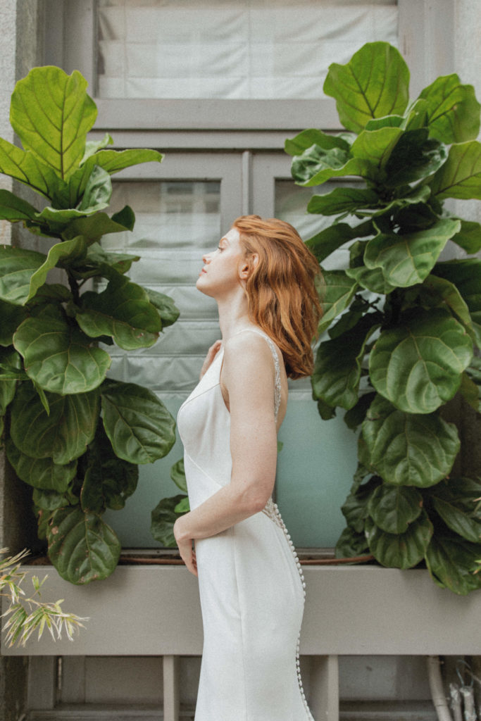 bride posing in front of plants 