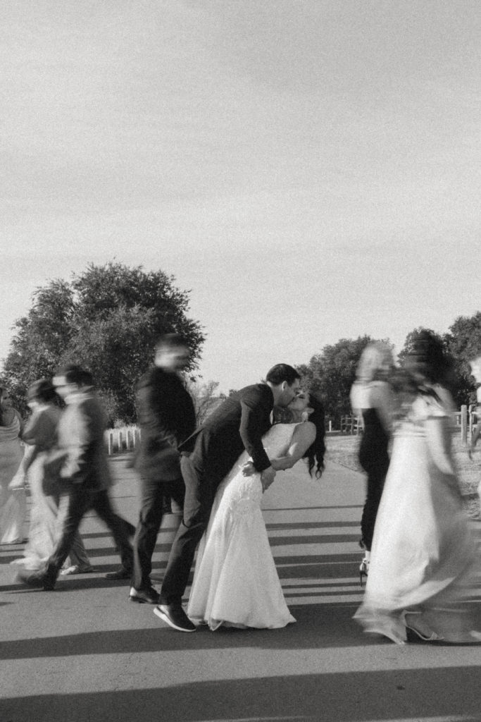 blurry black and white photo of bride and groom kissing 