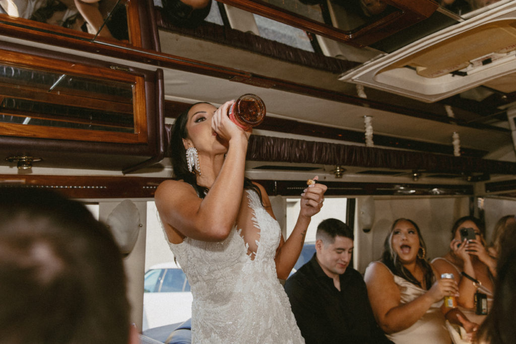 bride drinking on a party bus