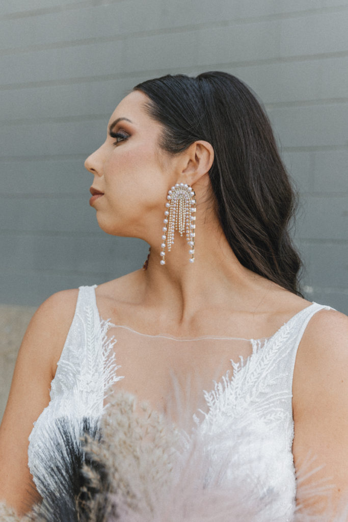 bride showing off her earrings 