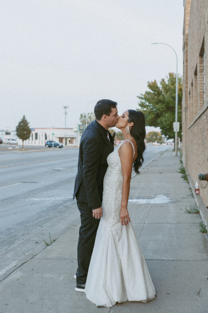 bride and groom kissing downtown 