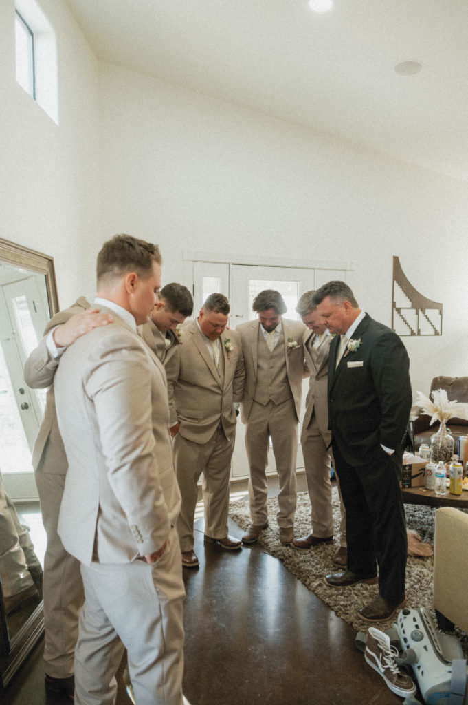 groom praying with his friends 