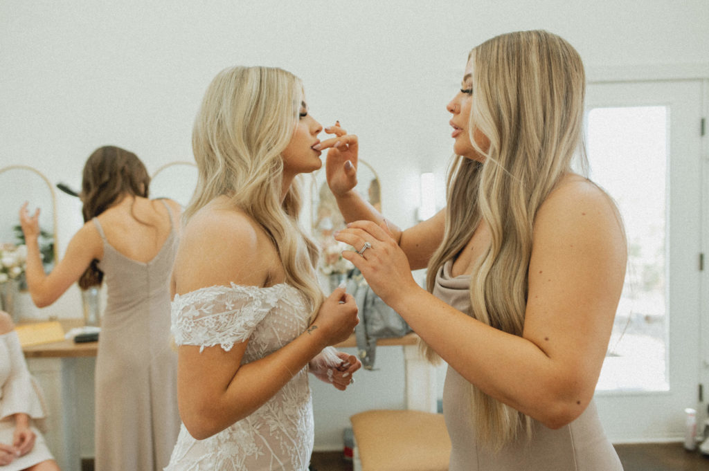 bride and bridesmaid getting ready 