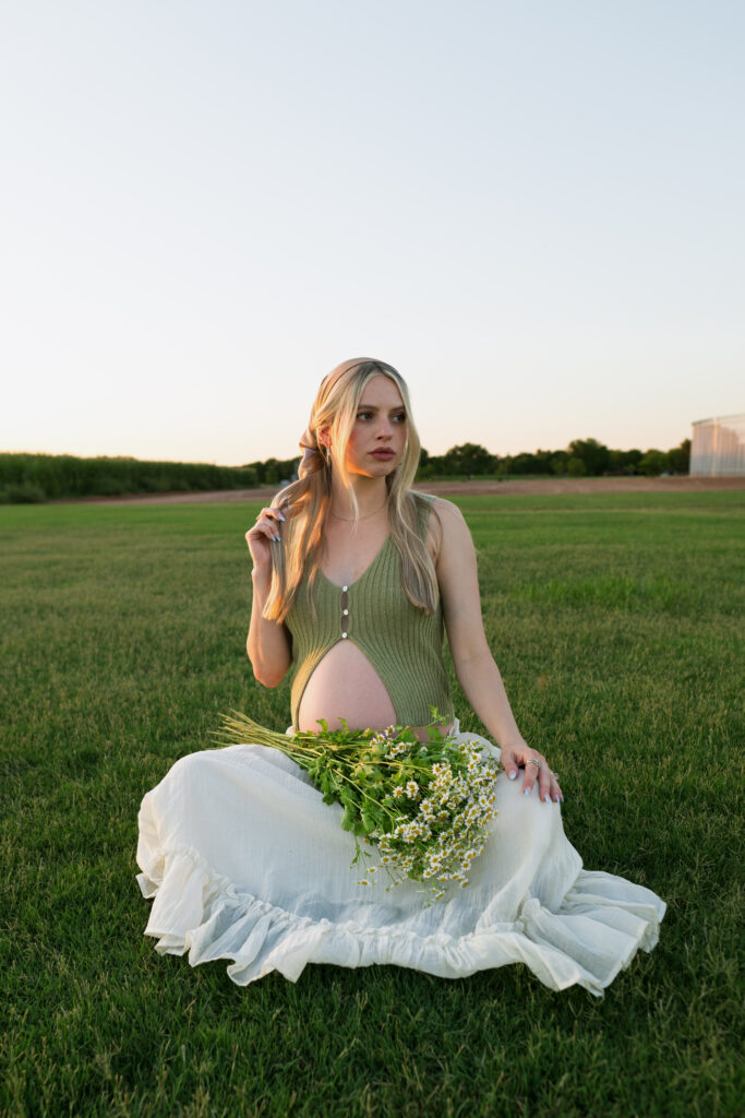 sitting maternity portrait in a field