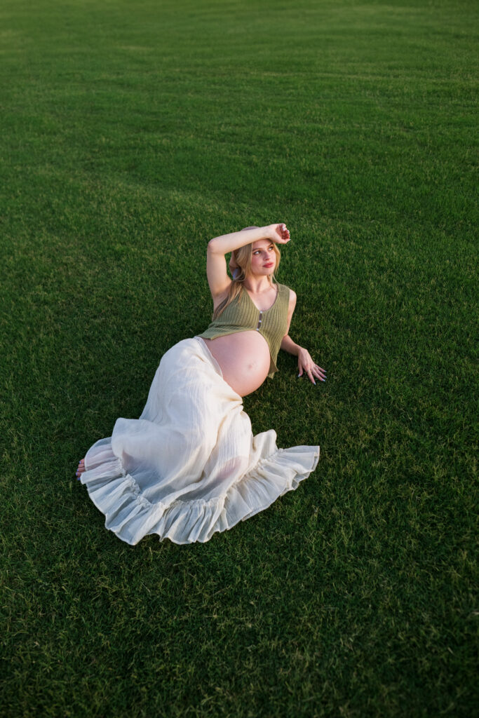 maternity photo laying in a field
